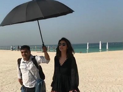 parineeti chopra makes another person carry an umbrella for her on a beach in dubai