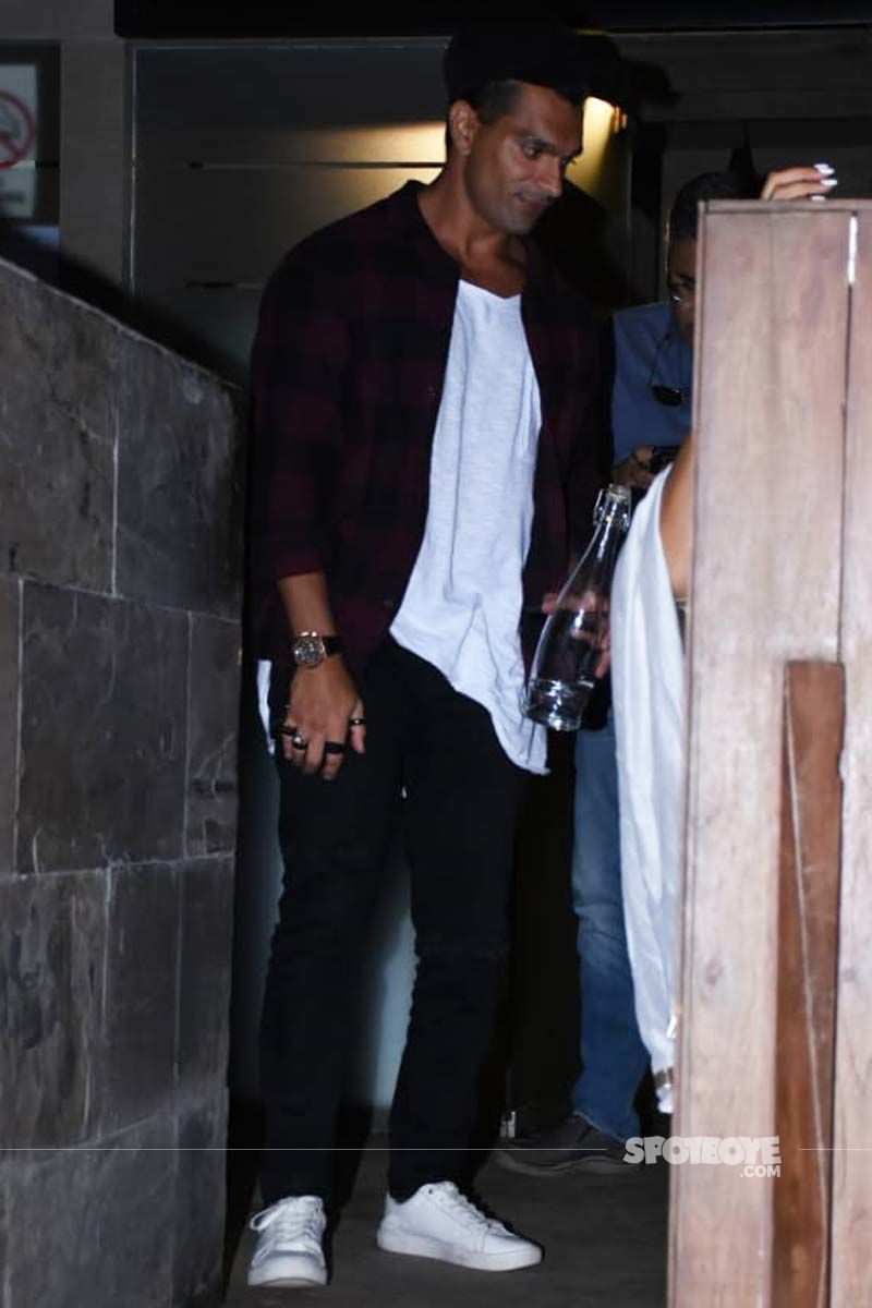 Keeping it casual Karan Singh Grover is seen sporting a white oversized t-shirt with maroon checkered shirt and black denims (Image Source: Viral Bhayani)