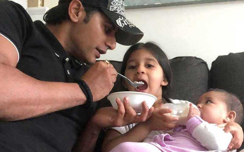 Karanvir Bohra Shares A Cutesy Pic Of Him Feeding His Daughter; Reveals He Chases Twins To Feed Them, Asks, ‘Ok At What Age Does This Stop?’