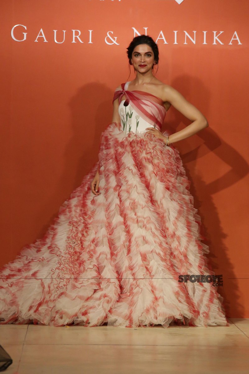 deepika padukone posing for the shutterbugs donned in red and white carnation