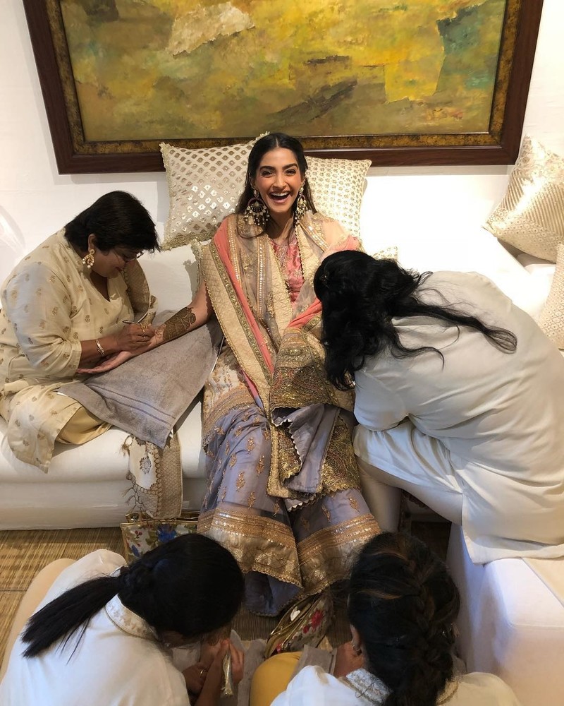 sonam kapoor s poses for a picture while applying mehendi