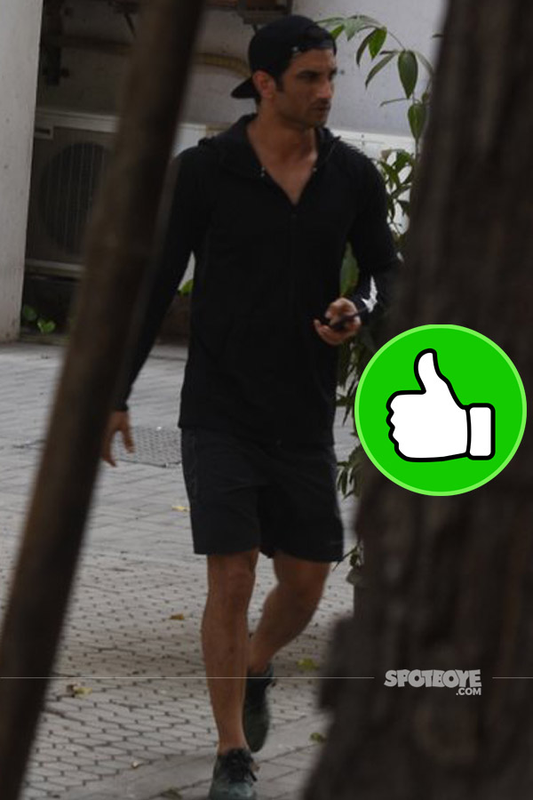 sushant singh rajput sported a casual look with a black sweat shirt and shorts and a cap 